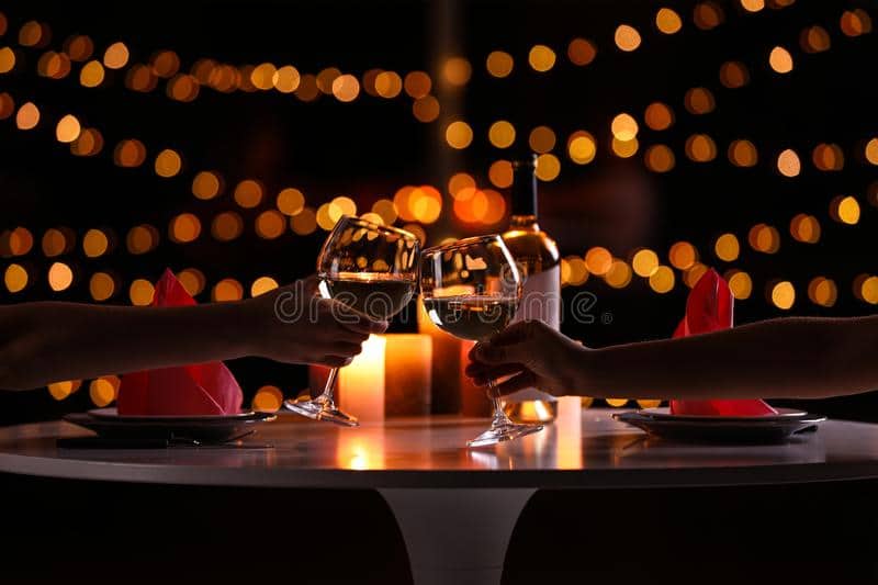 un-jeune-couple-avec-des-verres-de-vin-dîner-romantique-aux-chandelles-à-table-petit-closeup-160129039 Diner aux chandelles