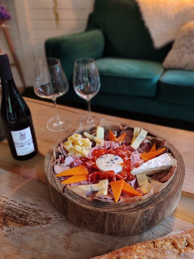 Plateau apéritif, vin et deux verres sur la table basse du chalet